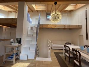 a living room with a staircase and a table and chairs at La Piccola Casa al Lago - Intera casa con 3 camere e 2 box in Salò