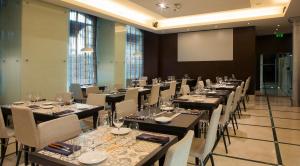 a conference room with tables and chairs and a screen at TURIM Restauradores Hotel in Lisbon +21 photos