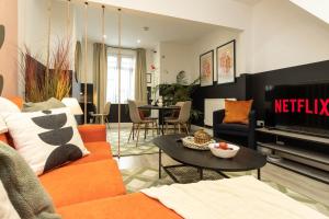Eden House في كوفينتري: غرفة معيشة مع أريكة برتقالية وطاولة