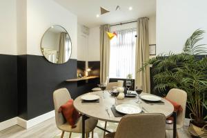 Eden House في كوفينتري: غرفة طعام مع طاولة وكراسي ومرآة