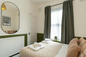 a bedroom with a bed and a mirror at Eden House in Coventry