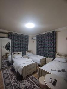 um quarto com duas camas e um espelho em Qozi Hotel em Samarkand