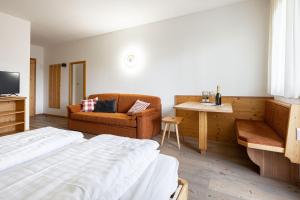 una camera d'albergo con letto e divano di Grünwald a Salorno