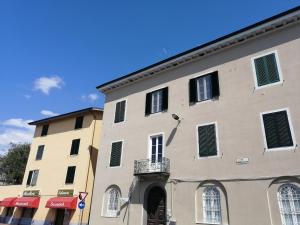 een groot gebouw met groene luiken erop bij Casa Sansevera Lucca in Lucca