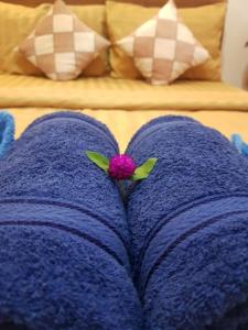 a purple blanket with a pink flower on top of it at Bloom Garden Bed & Breakfast in Siem Reap