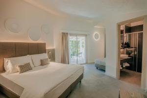 a bedroom with a large bed and a bathroom at AMASEA Resort in San Teodoro