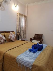 una camera da letto con un letto con una coperta blu sopra di Bloom Garden Bed & Breakfast a Siem Reap