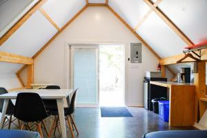 a room with a table and chairs in a attic at Wild Pines Cabins in Surrey