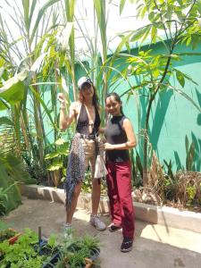 due donne in piedi l'una accanto all'altra in un giardino di Bloom Garden Bed & Breakfast a Siem Reap