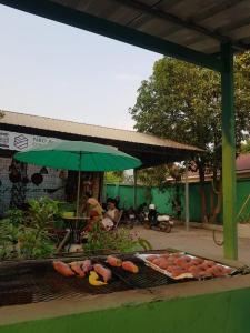een hoop groenten op een grill met een paraplu bij Bloom Garden Bed & Breakfast in Siem Reap