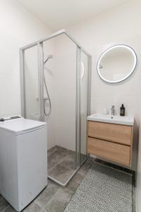 a bathroom with a shower and a sink and a mirror at Avocado apartment Victory port in Liptovský Mikuláš