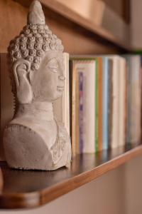 una estatua sentada en un estante junto a los libros en Sale Hotel, en Posada