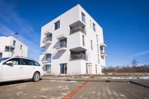 Avocado apartment Victory port في ليبتوفسكي ميكولاش: سيارة بيضاء متوقفة أمام مبنى