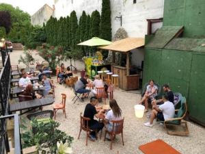 um grupo de pessoas sentadas em cadeiras em um pátio em Centrum Wellness Hostel em Debrecen