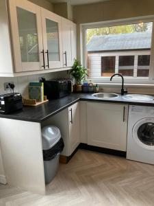 a kitchen with a sink and a washing machine at Modern cosy home sleeps 6 with parking nr Preston in Leyland