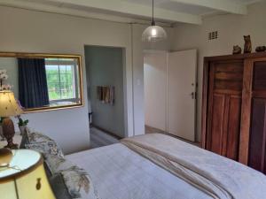 a bedroom with a bed and a window and a door at Clivedon Cottage in Sunland