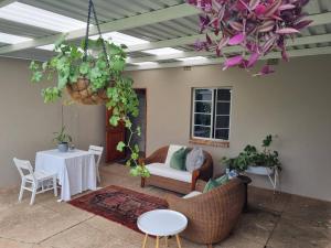 - un salon avec une table, des chaises et un lustre dans l'établissement Clivedon Cottage, à Sunland