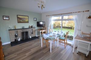 a dining room with a table and a fireplace at Aurora Bed & Breakfast in Castletown