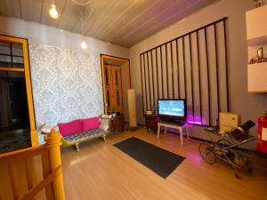 ein Wohnzimmer mit einem rosa Sofa und einem TV in der Unterkunft Faroway Hostel in Faro