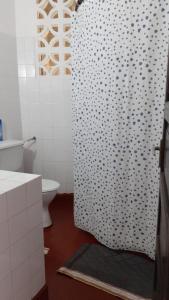 ein Bad mit einem Duschvorhang und einem WC in der Unterkunft Les Datchi Cottages in Diani Beach