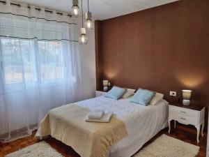 a bedroom with a bed and a large window at El Piso de María in Vigo