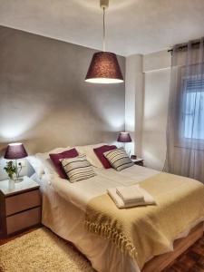 1 dormitorio con 1 cama grande y 2 almohadas en El Piso de María, en Vigo