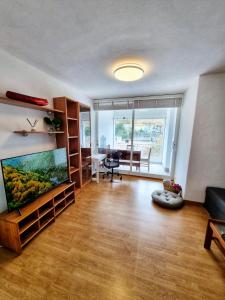 a living room with a large flat screen tv and a desk at El Piso de María in Vigo