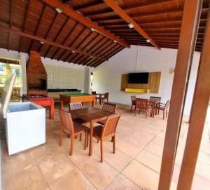 un patio con tavolo, sedie e camino di Casa em Condomínio Fechado com Sauna e Piscina a Salinópolis