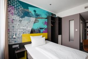 um quarto com uma cama e uma parede colorida em Hotel Berlin, Berlin, a member of Radisson Individuals em Berlim