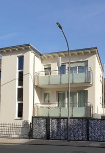 a white house with a fence and a street light at Hochwertige 85qm-Wohnung in Wuppertal-Vohwinkel in Wuppertal