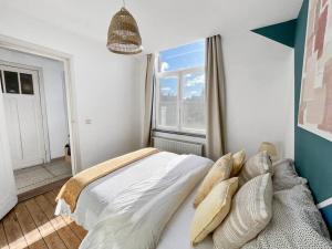 sypialnia z łóżkiem z poduszkami i oknem w obiekcie Cozy Antwerp - Zurenborg Skyline FREE PARKING w Antwerpii