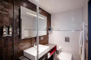 a bathroom with a sink and a toilet at Hotel Berlin, Berlin, a member of Radisson Individuals in Berlin