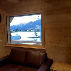 Sofá en habitación con ventana grande en Les Etoiles de Vonnes 2 en Châtel