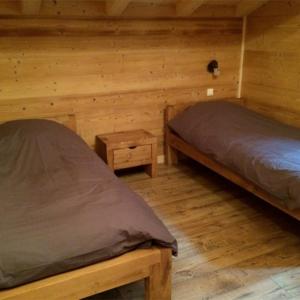 2 camas en una habitación con paredes de madera en Les Etoiles de Vonnes 2 en Châtel