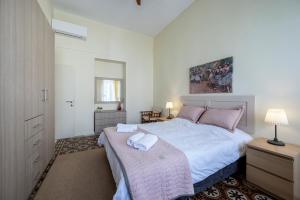 a bedroom with a large bed with white sheets and pink pillows at Casa Vecchia 1930’s Central Masterpiece in Kos Town +46 photos