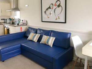 a blue couch sitting in a living room at Puffins in Port Isaac