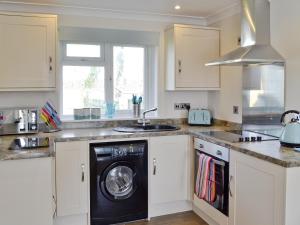 a kitchen with a washer and dryer in it at Puffins in Port Isaac