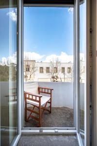 a sliding glass door with a bench on a balcony at Casa Vecchia 1930’s Central Masterpiece in Kos Town