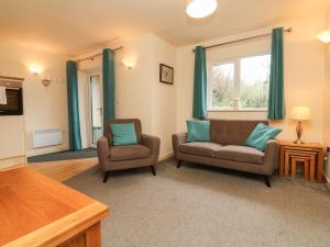 a living room with two chairs and a window at Larchwood Lodge in Ilfracombe