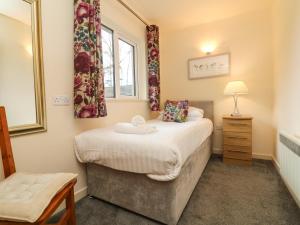 a small bedroom with a bed and a window at Larchwood Lodge in Ilfracombe