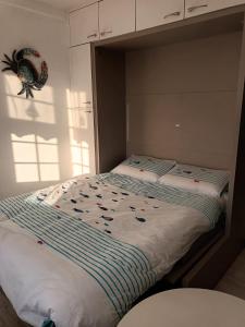 sypialnia z łóżkiem z kołdrą w obiekcie LE PETIT CABOURG de LA COUR NORMANDE Studio coeur de ville -1 à 2 personness w mieście Cabourg