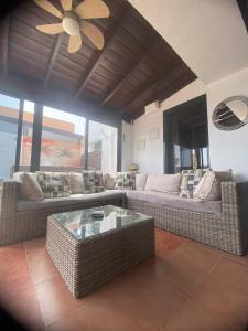 sala de estar con sofás y ventilador de techo. en CASA ORILLA! Beautiful private holiday villa with hot tub, en La Oliva