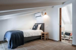 Un dormitorio con una cama y una silla en una habitación. en Casa Roques 16, en Jávea