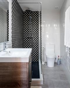 Un baño con un lavabo blanco y un inodoro. en Casa Roques 16, en Jávea