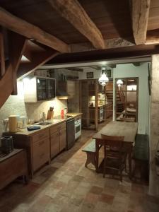 uma grande cozinha com uma mesa de madeira e uma sala de jantar em la tour du fauconnier em Doué-la-Fontaine