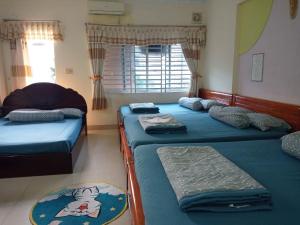 1 dormitorio con 3 camas y ventana en Motel Thanh Huyền en Vung Tau