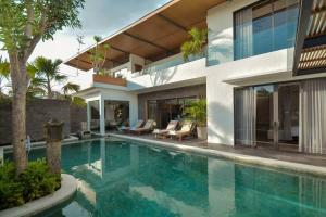 una imagen de una casa con piscina en The Kesari Luxury Villa, en Sanur
