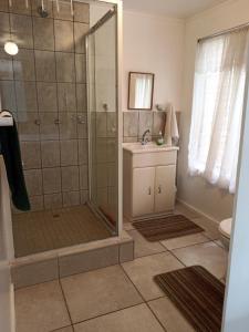a bathroom with a shower and a sink at Whispering Waves in Bazley Beach