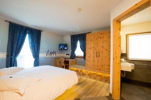 a bedroom with a bed and a large window at Hotel Pontiglia in Livigno