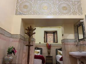 Habitación con baño con cama y lavabo. en Riad Douja, en Marrakech